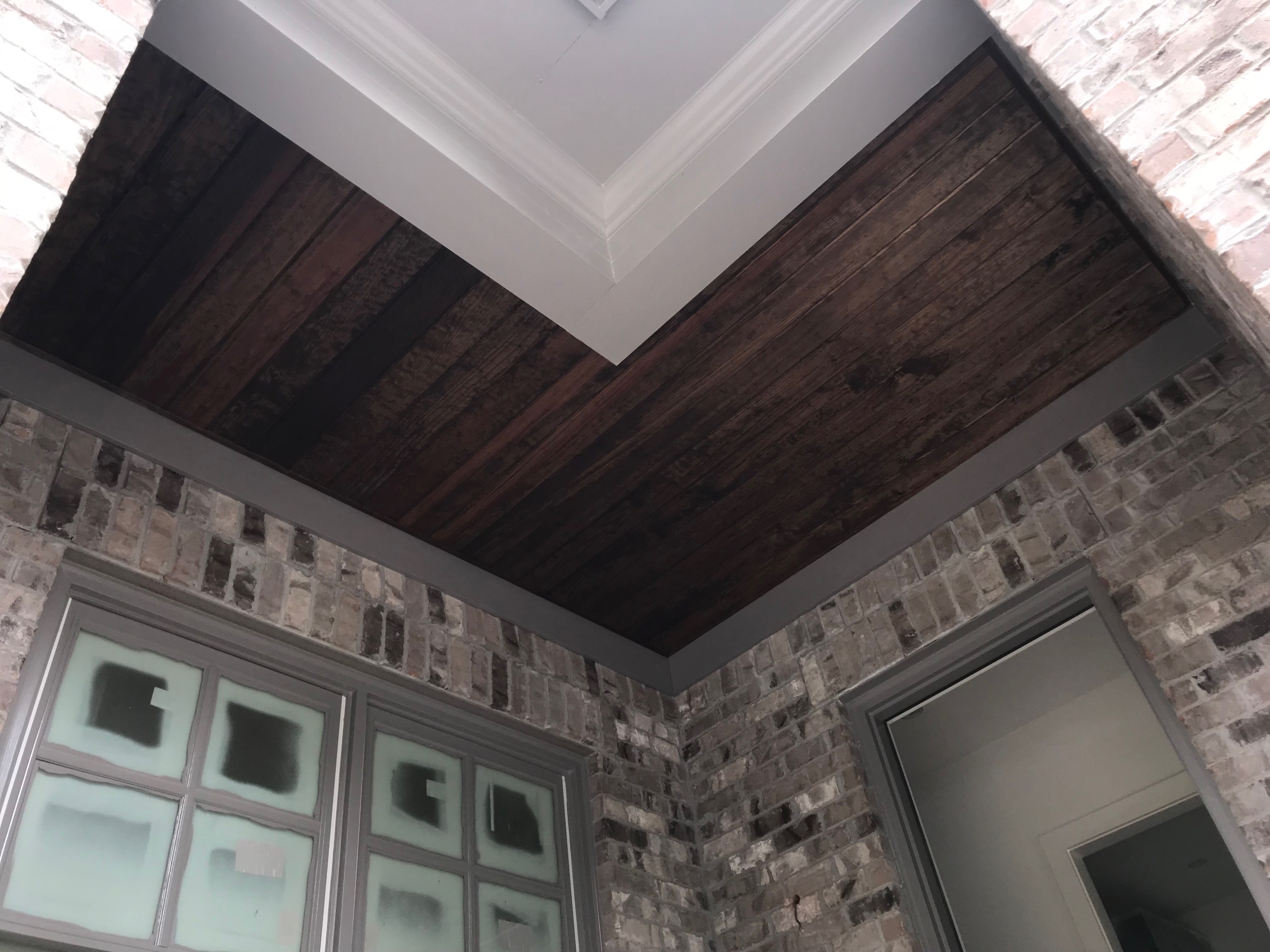 Finished interior with stained wood ceiling and brick walls
