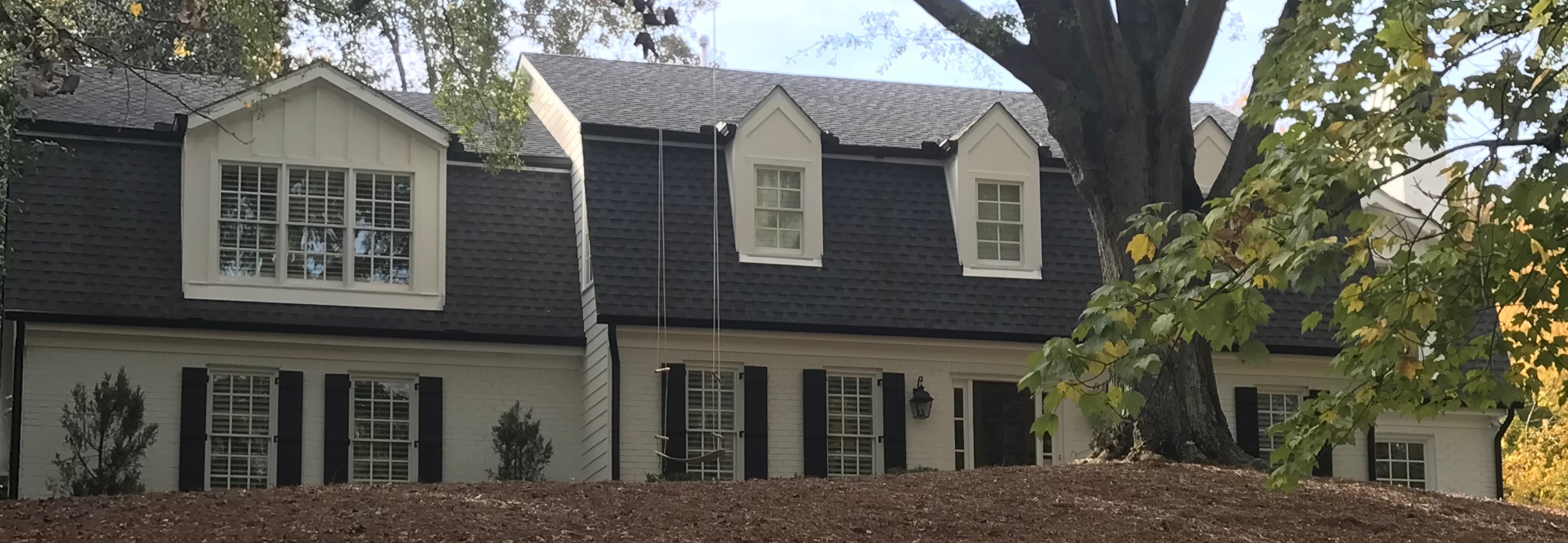 Beautiful finished residential exterior with black shutters and white siding